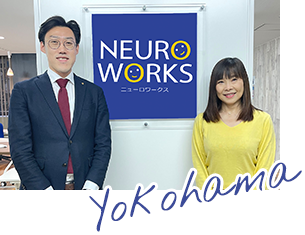 看板の前に並ぶニューロワークス横浜センタースタッフ