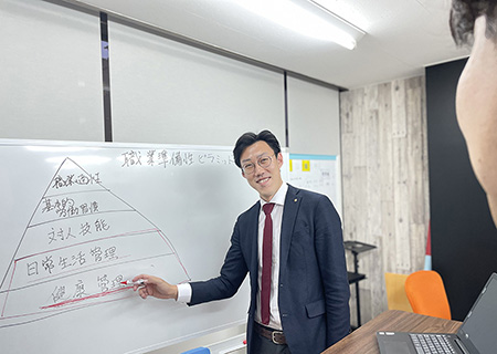 スライドの前で利用者さまに対して説明を行う男性スタッフ