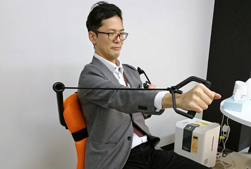 椅子に備えられたトレーニング器具で毎日スタッフブレインフィットネスを実行中のスタッフT氏