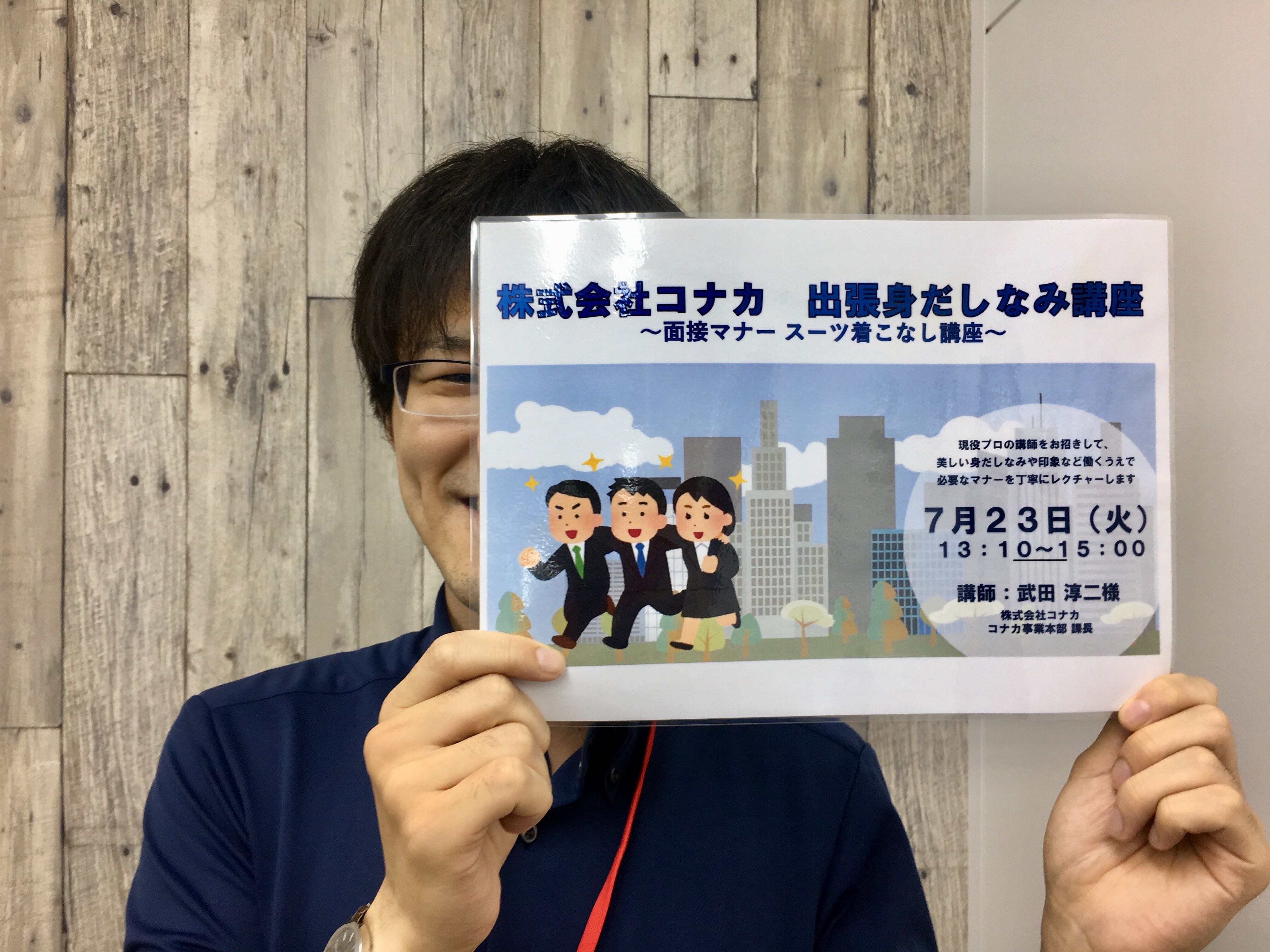 コナカ様出張プログラムの案内を持つスタッフ