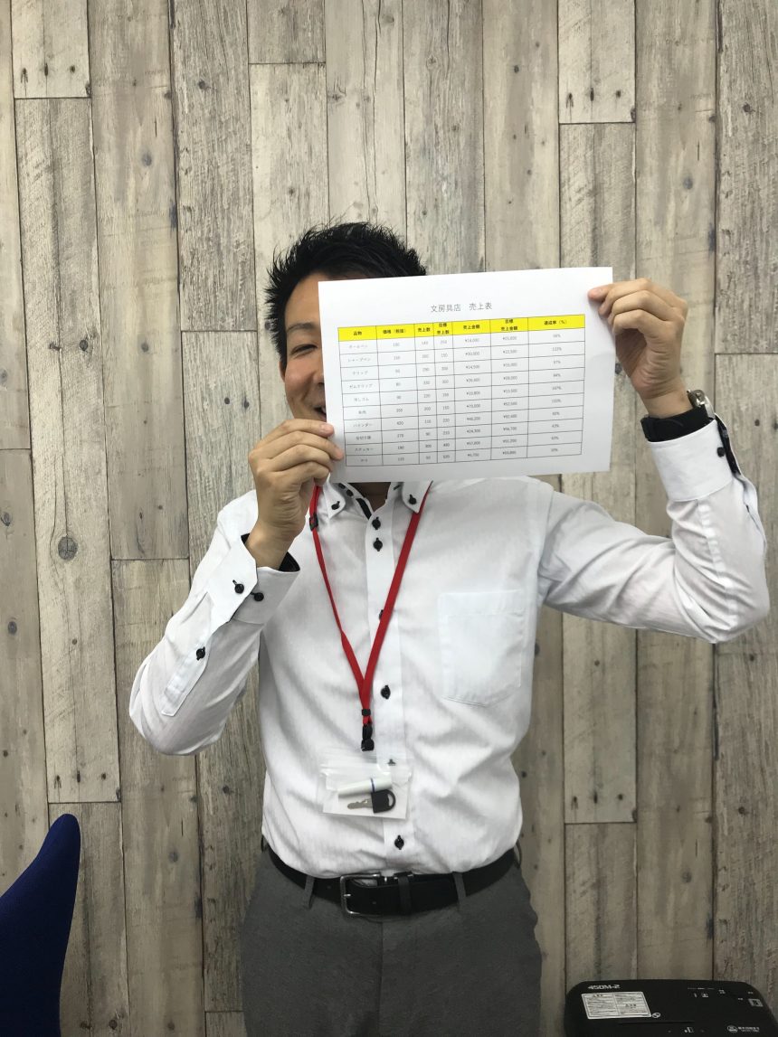 Excel講座で作成した表を持つスタッフ